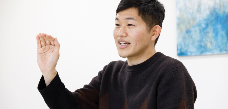 手を挙げて話している男性