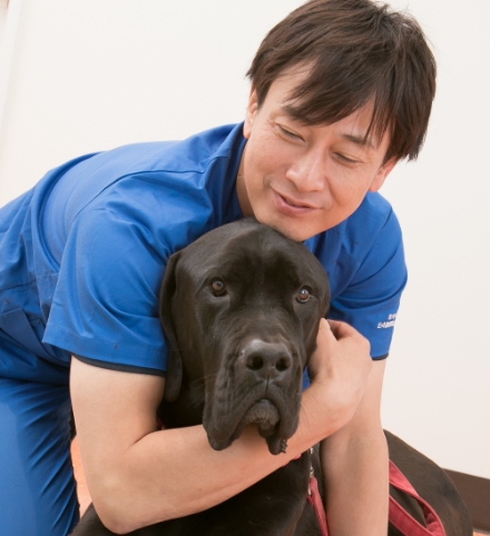 ラブラドールレトリバーミックスの大型犬を抱きしめる獣医師 淺井亮太先生