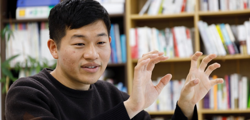 両手を挙げて話している男性