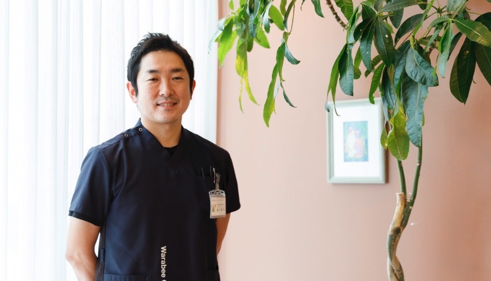 壁際で正面を見つめる獣医師の溝口先生