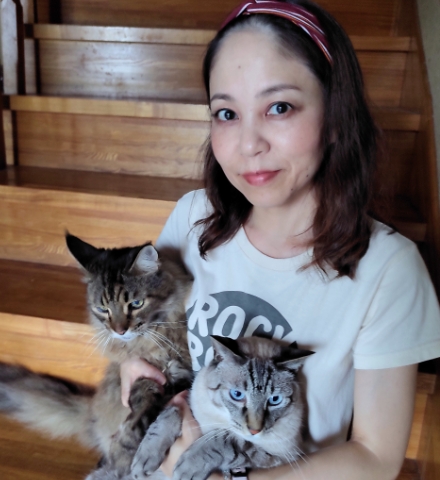 2頭の猫を抱っこする女性