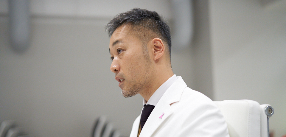 インタビューを受けている横顔の男性